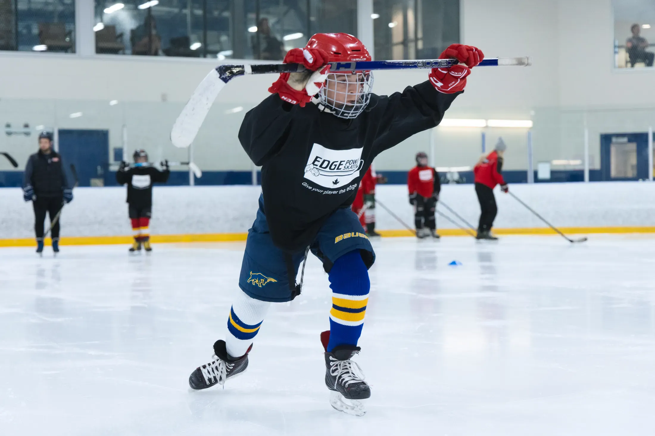 An Edge player in a low athletic drive, hard edge bite into the ice