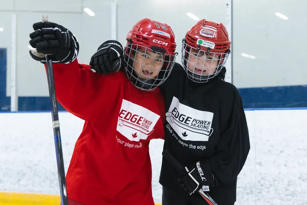 Edge coaches working with players on the ice — figure-skating background, hockey delivery